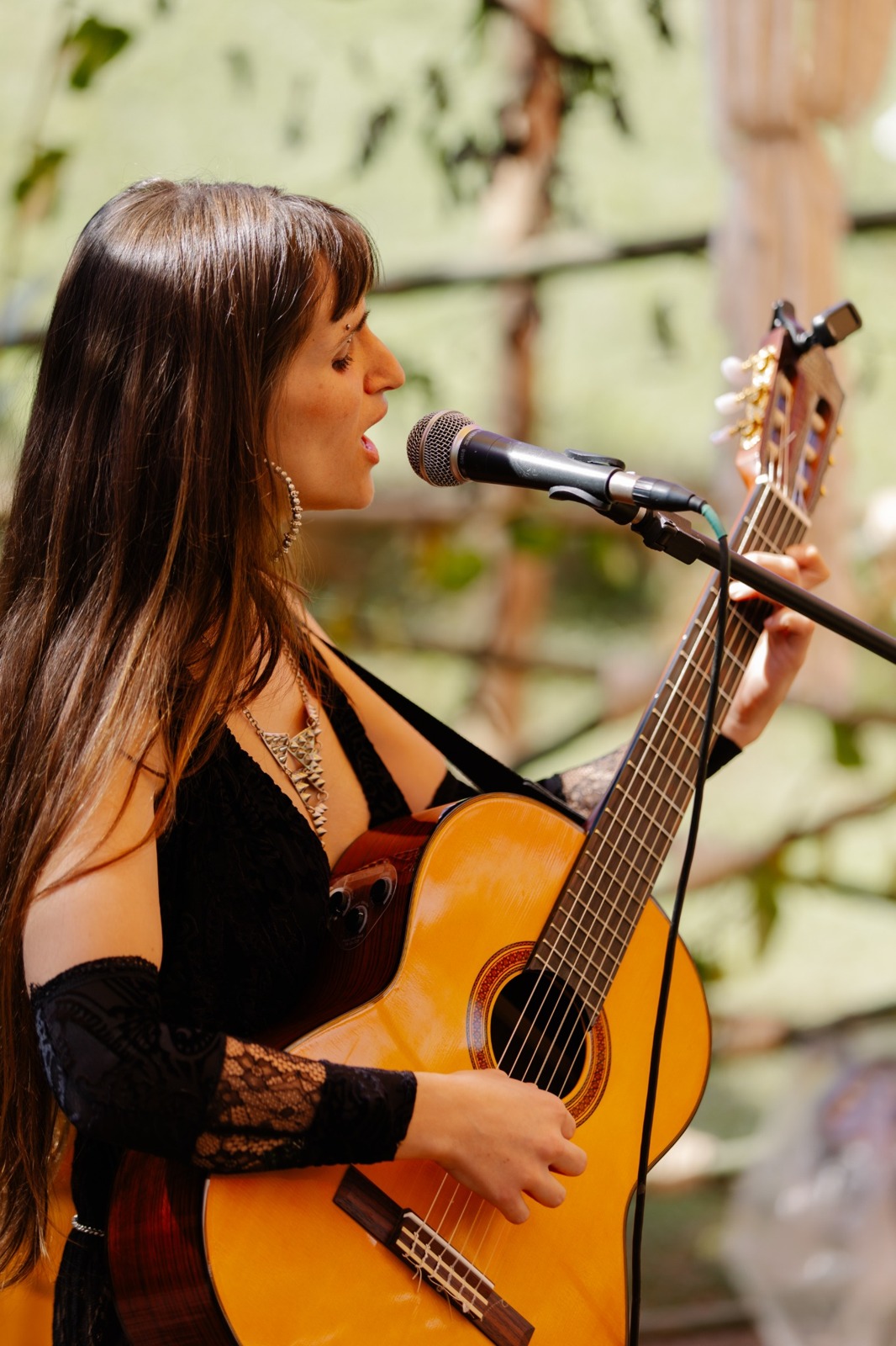 Joana Rochael cantando e tocando violão no festival Pulsar